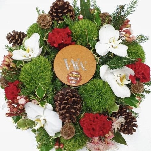 Green, red and white floral Christmas table centrepiece with phalaenopsis orchids, trix, flowering gum, cockscomb and pine cones