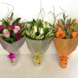 Three options of floral bouquets including pink flowers, white florals, and orange flower bouquet. Flowers used in the bouquets include roses, gerberas and lilies
