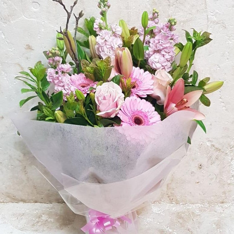 A pretty pink floral bouquet made up of roses, gerberas and lilies with selected greenery