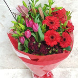 A beautiful bouquet of red flowers with tulips, gerberas and lilies